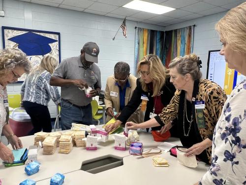 Meriwether co Rotary Club with Dist Gov Andre Marria putting together Its a Girls thing Bags (2).jpg